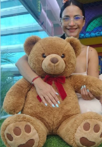 Julieta hugging a teddy bear in a playful profile photo