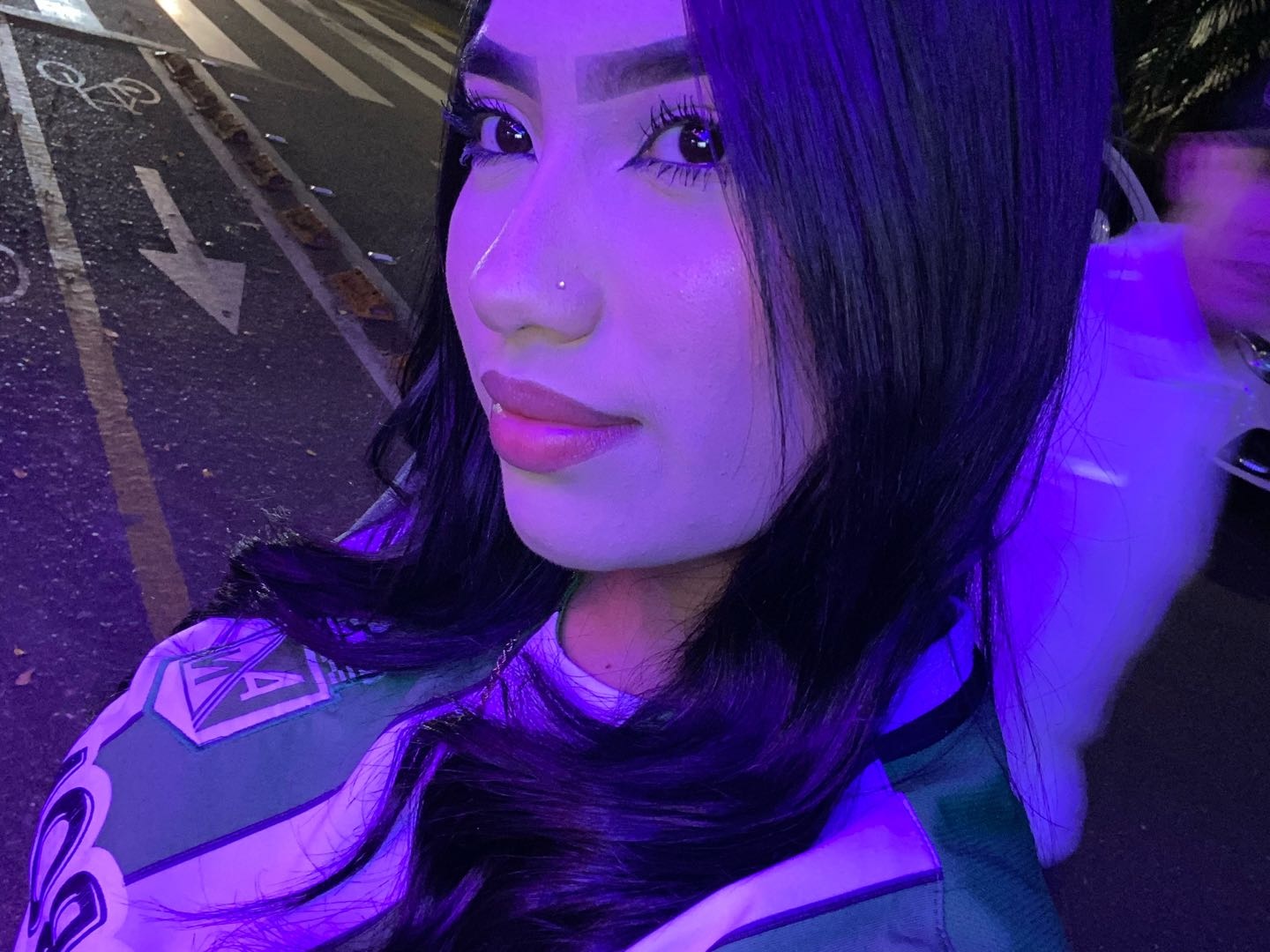Yésica on a night street, city lights behind her